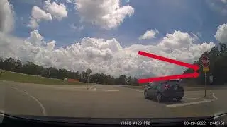 Rolling Through Stop Sign With Sign That Says 