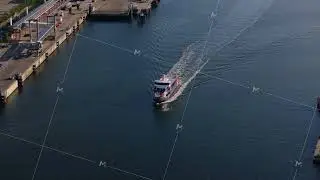 Aerial view of a boat leaving the harbor in Kiel, Germany. The ferry is sailing on the calm water