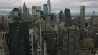 Forwards fly above city. Modern tall skyscrapers in business hub against cloudy sky. Manhattan, New