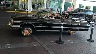 Lowrider chevy Impala with hydraulics hitting switches on gold rims