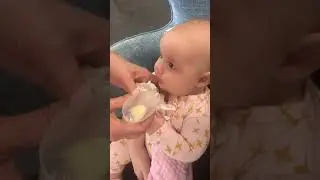 Cup feeding an older baby.