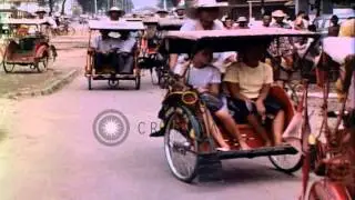 Locals traveling in bicycle taxi vehicles through crowded streets of downtown Jak...HD Stock Footage