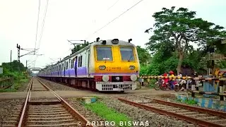Aerodynamic staff cum patrolling special EMU train passing through a busy level crossing