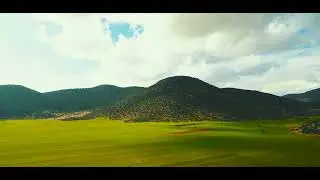 🌄🚜 Farmland Serenity: 4K Aerial View of Farms Nestled Among Majestic Mountains 🌾🎥