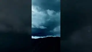 Untamed skies! Dramatic storm clouds swirl above a rugged landscape. Intense, breathtaking views.