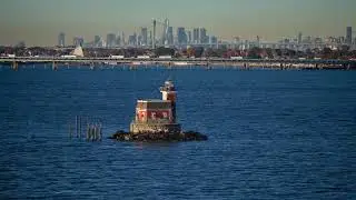 Drone video around Stepping Stones Light House, With Throgs Neck Bridge and the Manhattan Skyline.