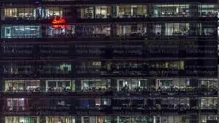 Modern office building with big windows at night timelapse, in windows light shines