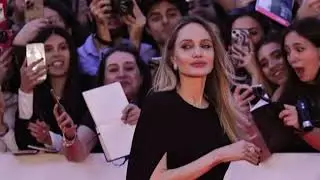 Анджелина Джоли демонстрирует свои татуировки в открытом черном платье