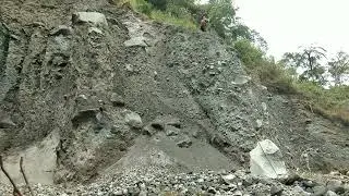 manual sand miner stands proudly on a cliff to break down black sand