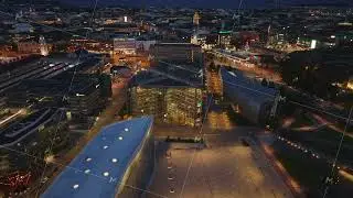 High angle view of steel and glass design building in modern urban borough. Tilt up reveal of night
