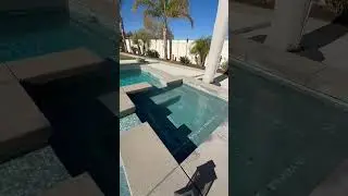 The waterline tile on this pool build is the star of the backyard!