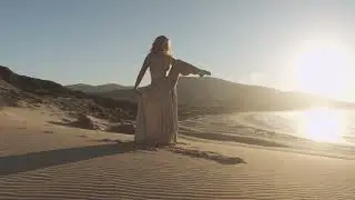 woman in golden dress dancing on sunlit beach 2025 12 17 12 40 42 utc