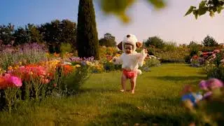 Adorable Baby in a Dog Costume Walking in a Garden