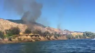 Couple helps put out brush fire with their jet boat.