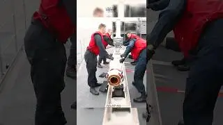 U.S Sailors load a RIM-7P NATO Sea Sparrow missile into its launcher.