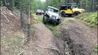 Jeep LJ straddling a washout