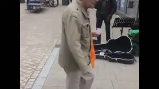 Mike Joyce drops some money to a busker
