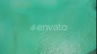 Daytime aerial island view of a white sand paradise beach and blue sea background in colorful 4K...