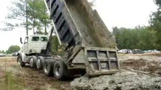 Dump trucks dumping mud