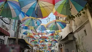Colorful decoration umbrellas hang overhead above a walking pedestrian street in George Town, Penang