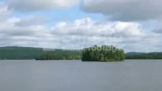 Trout Lake, North Bay stock video. Cottage country landscape. Island & speedboat in the distance. 4K