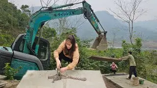 The driver and the girl drive the truck transporting the excavator. Concrete lid crane.