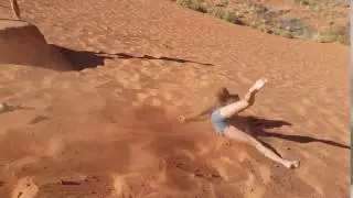 Blonde girl loses balance sand hill