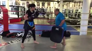 Muay Thai master Peter Sisomphou holding kick pad