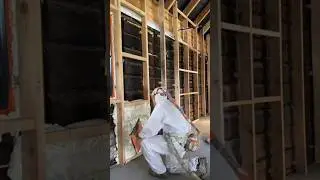The process of applying spray foam to walls to control room temperature