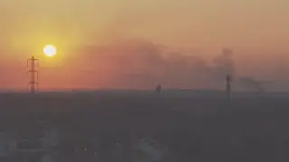 Columns of dark smoke float across skyline as sun sets over Gaza Strip