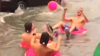 British tourists play on inflatable rubber rings in flood