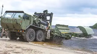 Модифицированный американский армейский грузовик сбрасывает массивный ленточный мост в воду