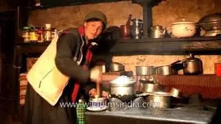 Ladakhi woman makes butter tea in her house