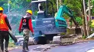 Beginilah cara Beko Mini Kobelco SK50 Berjalan di aspal baru , untuk perapian Tepi jalan.