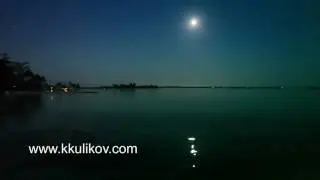 Night. The moon over the sea and reflection in water