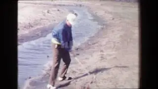 1968: Man hitting golf ball out of sand hazard creek water hazard. LOS ANGELES, CALIFORNIA