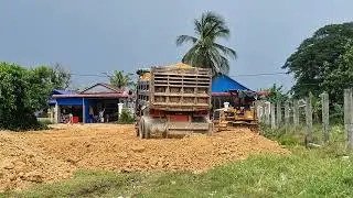 A bulldozer hauls dirt to clear rice fields and digs up soil to build rental apartments.