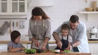 Happy family mom dad and kids siblings cooking together, young parents teaching children son daughte