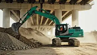 The Green Excavator Operating Near a Small Bridge
