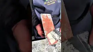 Spatula spreads smooth coat, textured block layered with finishing material.