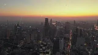 Aerial view of Bangkok's urban landscape at dusk from a tripod. City glows with lights from
