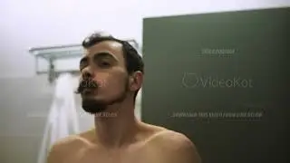 Man with concentrated expression preparing himself with grooming tools in calm evening environment