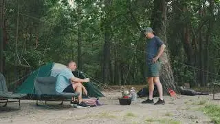Two men cook and talk together, Two individuals collaborate on cooking while having friendly chat