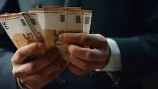 VideoVault Stock Video: Man in suit counts 50 euro bills with his hands