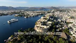 Glimpse view of shining City Palace from the sky Udaipur Rajasthan against aquamarine Pichola waters