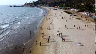 Arambol Goa India drone fly over a sunset beach, people walk along the sunset beach