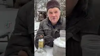 Russian man takes a sip of vodka and then bites into ice