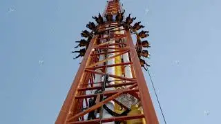 free fall attraction with people on a blue sky background
