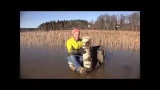 Guy hits log on ice lake