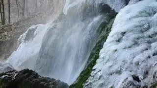 The partially frozen Bad Urach waterfall in winter.